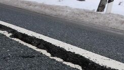Aufgerissener teil einer Straße im Winter bei Schnee