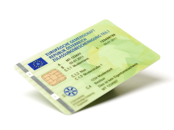 Scheckkartenformat einer Zulassungsbescheinigung Teil 1 in Österreich. Die Karte ist grün, hat Sicherheitsmerkmale und verschiedene Infos.
