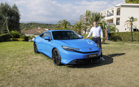 Eine Person steht neben einem blauen Honda Prelude.