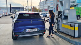 Eine Frau betankt ein blaues SUV