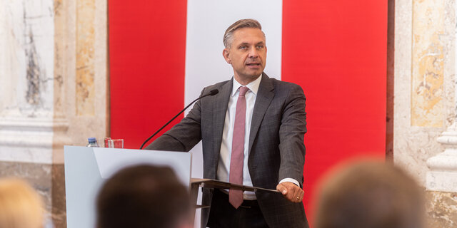 Wirtschaftsminister Hattmannsdorfer spricht an einem Redepult
