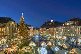 Stimmung in der Dämmerung: Weihnachtsmarkt am Hauptplatz von oben mit Weihnachtsbaum.