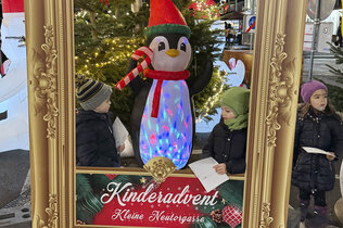 Bilderrahmen mit drei Kindern am Adventmarkt.
