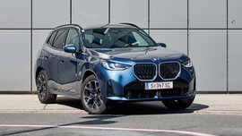 Großes, blaues SUV vor einer grauen Wand