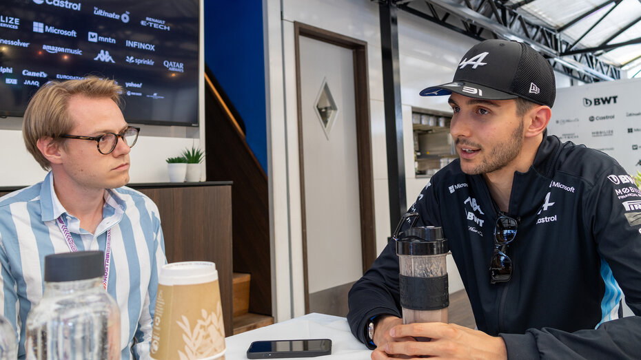 Der Formel-1-Fahrer Esteban Ocon unterhält sich mit einem Journalisten.