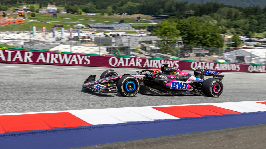Ein schwarz-pinkes Formel 1 Auto fährt über den Red Bull Ring.