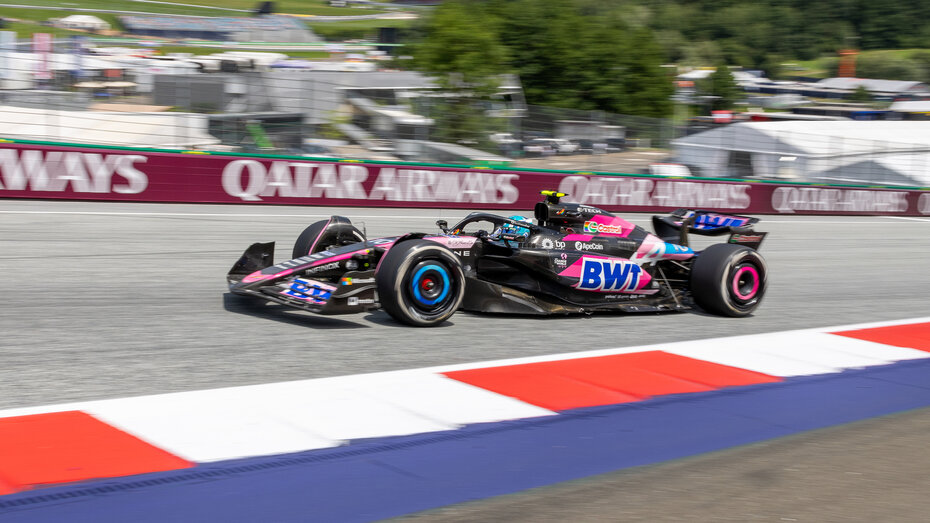 Ein schwarz-pinkes Formel 1 Auto fährt über den Red Bull Ring.