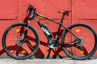 E-Bike der Marke KTM steht vor rotem Tor.