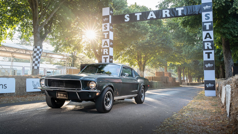 Ein dunkelgrüner Ford Mustang auf einer Rennstrecke