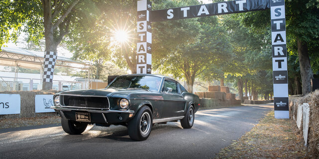 Ein dunkelgrüner Ford Mustang auf einer Rennstrecke