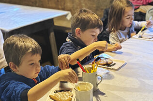 Drei Kinder verzieren ihren Lebkuchen.