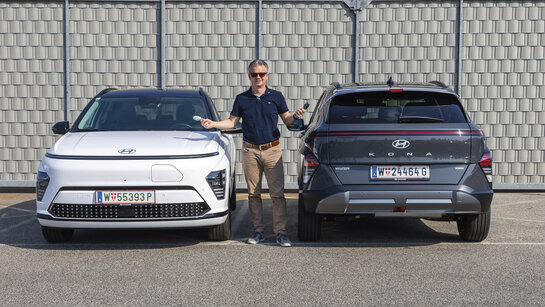 Hyundai Kona in grau und weiß, dazwischen ein Mensch