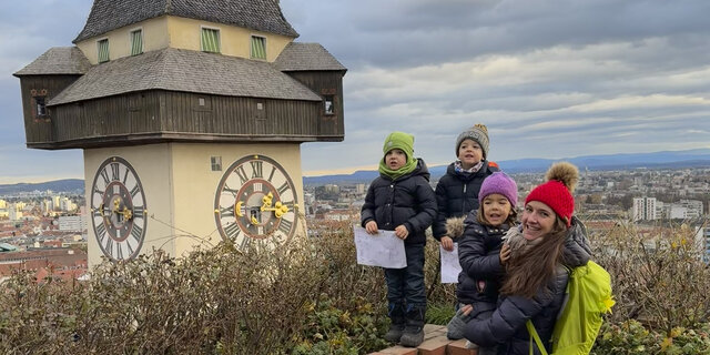 Redakteurin Conny mit ihren Drillingen am Schlossberg in Graz neben dem Uhrturm.