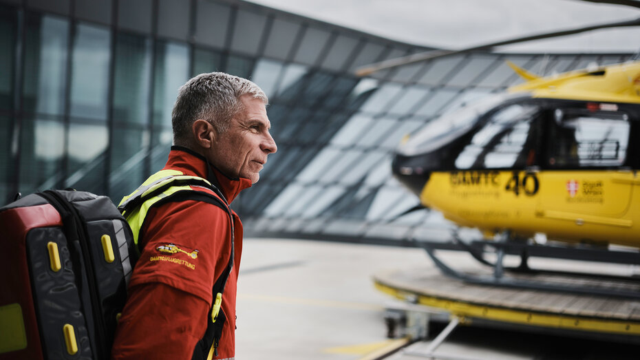 Wolfgang Voelckel vor Christophorus, Heli ist verschwommen im Hintergrund.