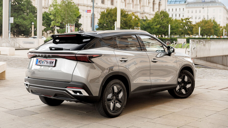Ein champagnerfarbenes SUV steht vor einer Garageneinfahrt