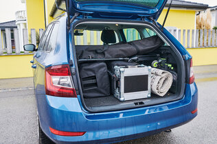 Das Heck eines blauen Kombis mit geöffnetem Kofferraum, in dem sich verschiedene Dinge befinden. Das Arbeitsmaterial von Sängerin Anna Pflamitzer.