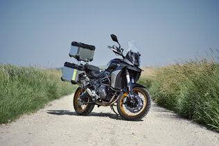 Die Mittelklasse Reiseenduro QJ SRT 700 SX mit drei am Heck montierten Alu-Koffern von schräg vorne hinten fotografiert.