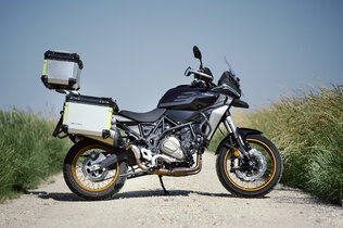 Die Mittelklasse Reiseenduro QJ SRT 700 SX mit drei am Heck montierten Alu-Koffern seitlich fotografiert.