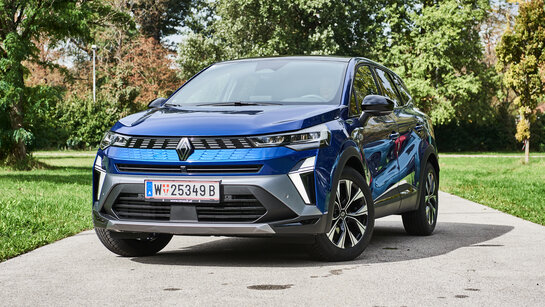 Ein blaues SUV steht in einem Park