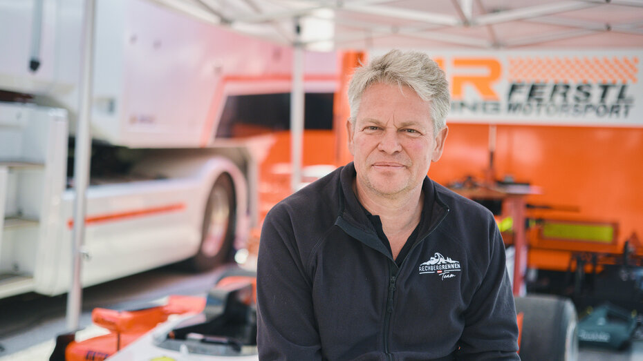 Eine Person steht vor einem Formel-Rennwagen.
