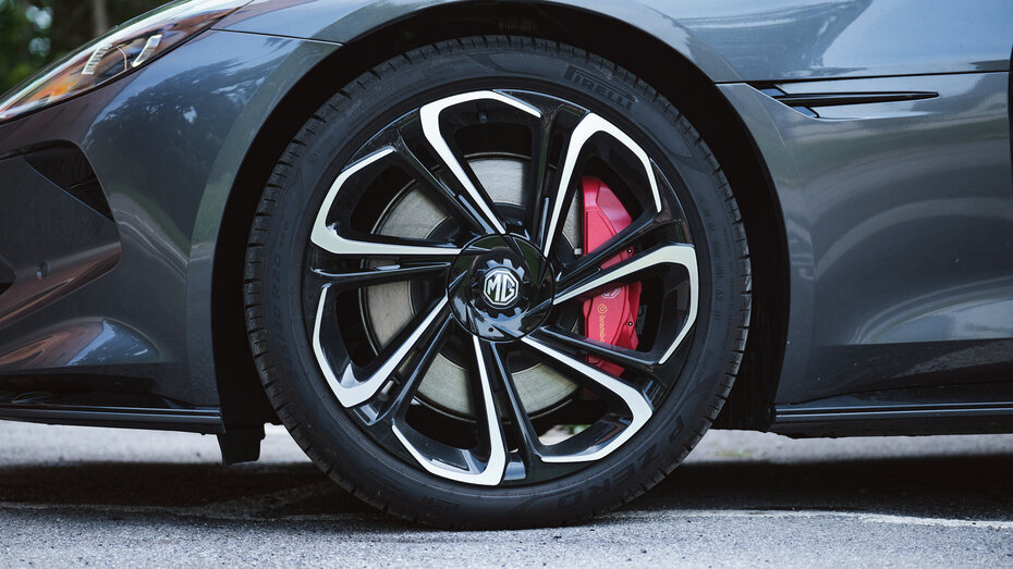 Felgen mit MG-Logo eines Autos, dahinter befindet sich ein roter Bremssattel.