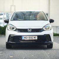 Ein weißer Honda Jazz steht vor einem Haus