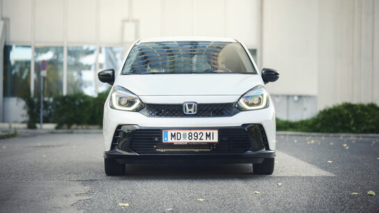 Ein weißer Honda Jazz steht vor einem Haus