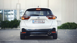 Ein weißer Honda Jazz steht vor einem Haus