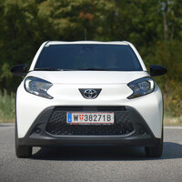 Ein weißer Toyota-Kleinwagen steht auf einem Parkplatz