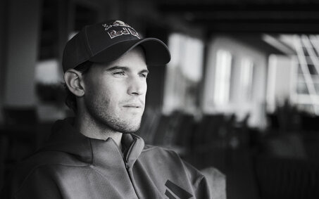 Schwarz-weiß-Foto des Ex-Tennisspielers Dominic Thiem, wie er in die Ferne blickt.