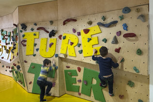 drei Kinder spielen und Klettern in der Kinder-Bereich im Jufa-Hotel.