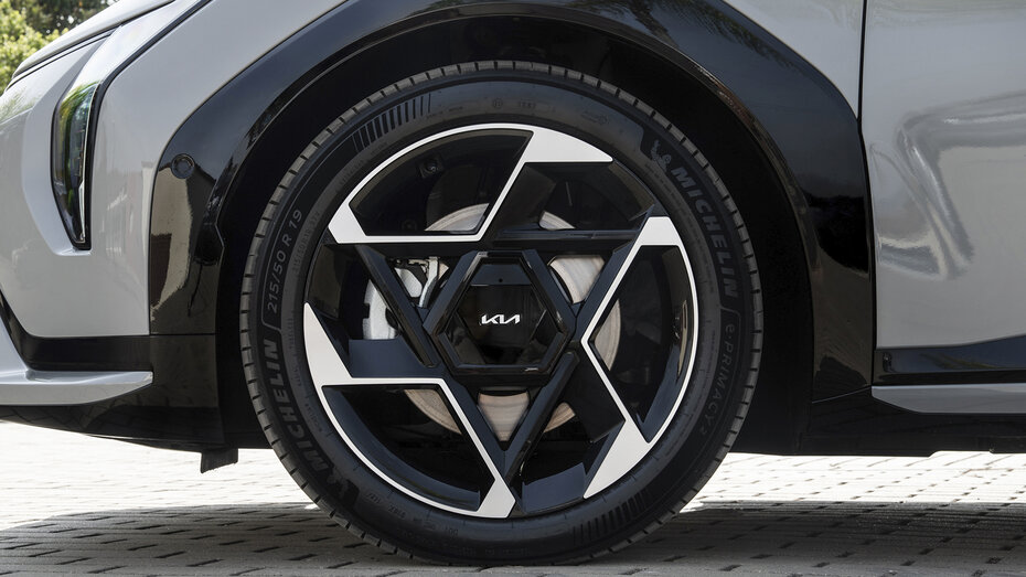 Schwarz-silberne Felgen eines grauen Autos der Marke Kia.