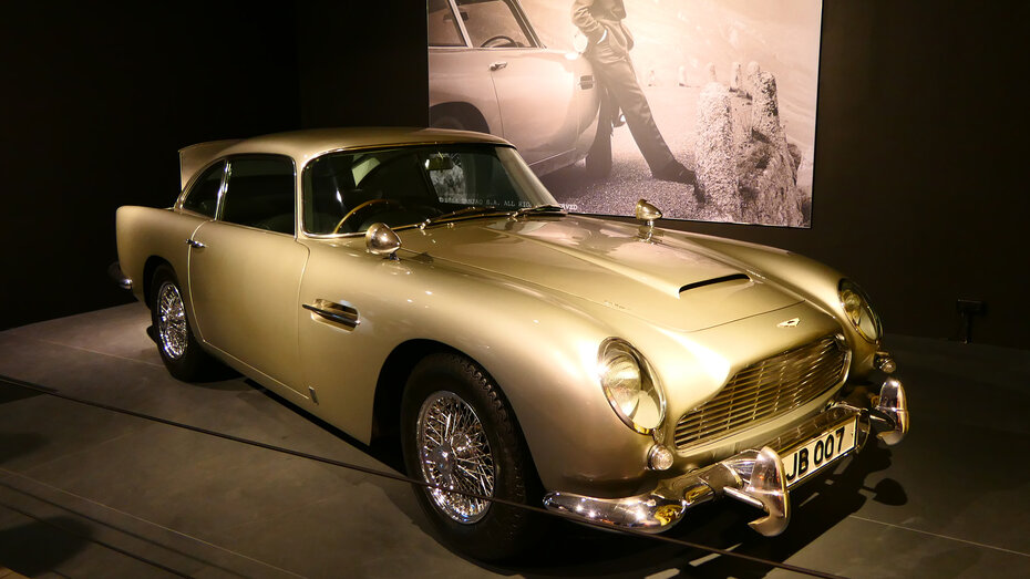 Ein silberner Aston Martin DB5 mit einer Leinwand im Hintergrund