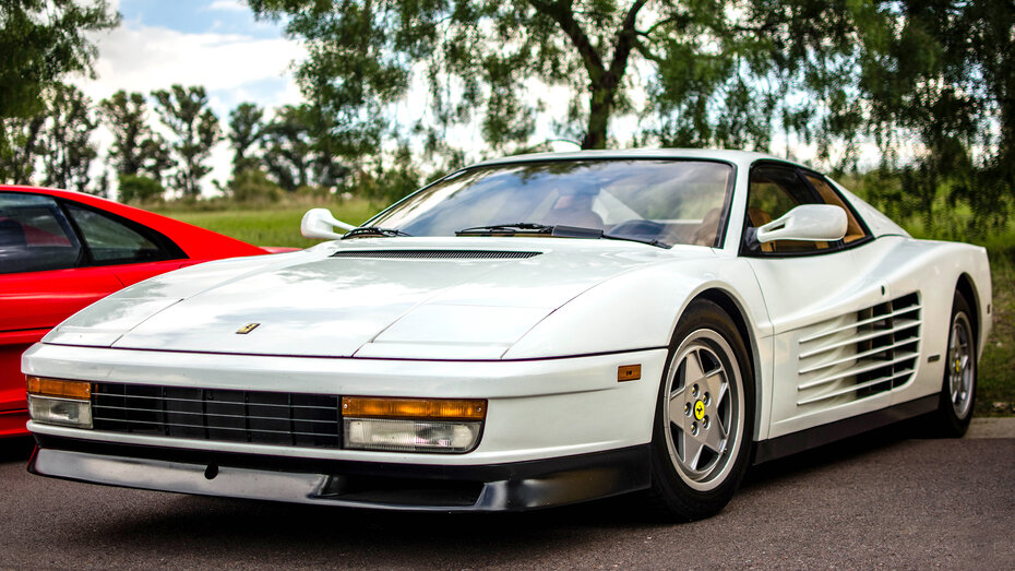 Ein weißer Ferrari Sportwagen steht auf einem Parkplatz
