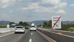 Autos in einem Baustellenabschnitt einer Brücke und ein Schild Ende der Kontrolle