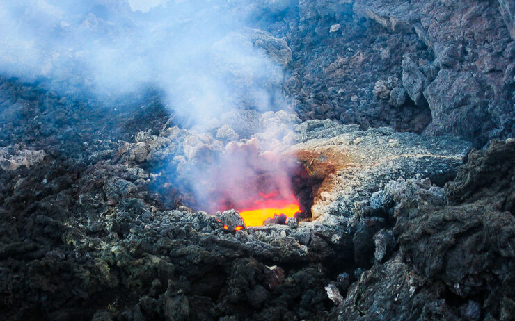 Ätna Das Foto zeigt einen detaillierte Aufnahme des italienischen Vulkans Ätna - eine Öffnung, in der heiß dampfende Lava zu sehen ist.