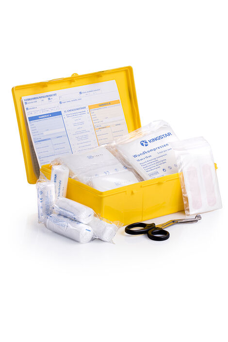 Geöffneter Plastikbox; man sieht den Inhalt der Box. Verbände, verpackte Einmalhandschuhe und eine Verbandschere liegen daneben.