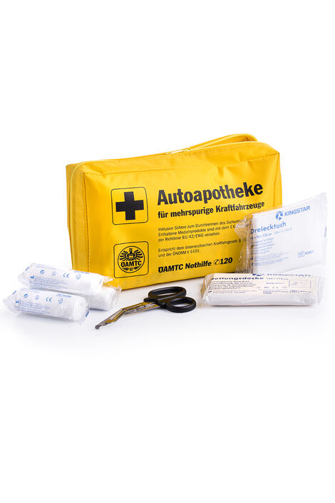 ÖAMTC Autoapotheke nach ÖNORM 5101 Weichverpackung 6647_2g Geöffnete Autoapotheke; davor liegen Verbände. eine Verbandschere, ein Dreiecktuch und eine Rettungsdecke.