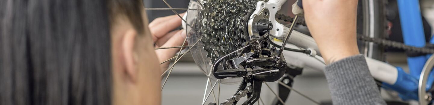 ÖAMTC Technikerin überprüft die Gangschaltung am Hinterrad