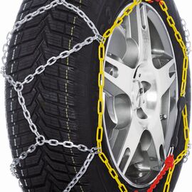 Schwarzer Reifen auf dem eine Schneekette montiert ist. Der Kette ist weiß. gelb und rot.
