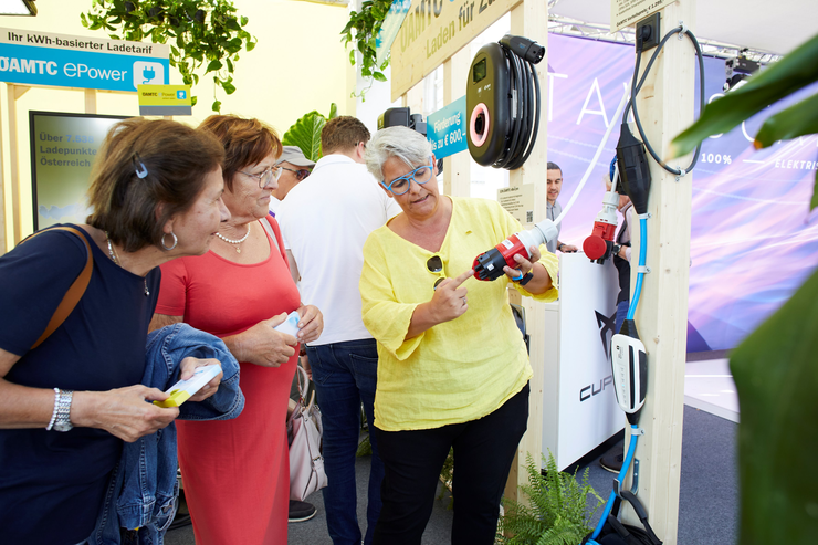 ÖAMTC Expertin berät zwei Kundinnen zum Thema Laden unterwegs mit dem ÖAMTC NRG Kick