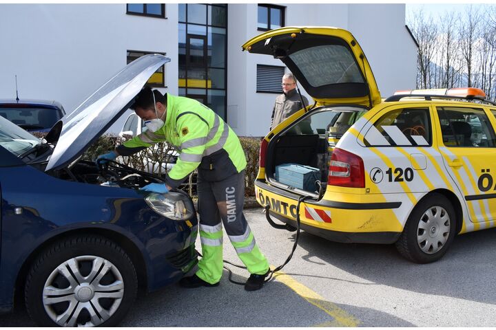 Pannenfahrer vor geöffneter Motorhaube