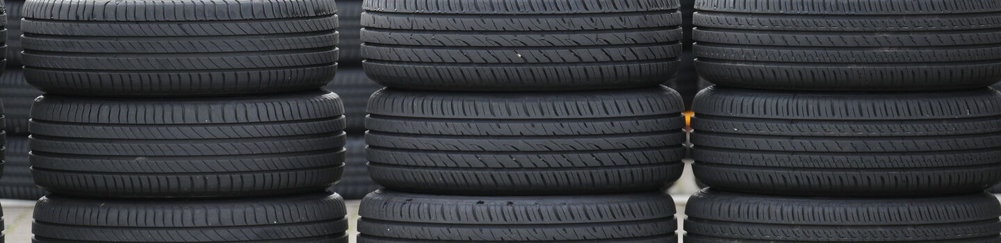 Viele schwarze Autoreifen gestapelt.