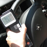 Man sieht ein Temperaturmessgerät, das über einem Auto-Lenkrad positioniert ist und 80 Grad Oberflächentemperatur anzeigt.