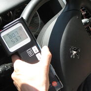 Man sieht ein Temperaturmessgerät, das über einem Auto-Lenkrad positioniert ist und 80 Grad Oberflächentemperatur anzeigt.