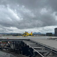 ÖAMTC_ITH-Rückholung Ljubljana (3).jpeg Ein gelber Hubschrauber auf einem Dachlandeplatz
