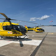 Zwei gelbe Notarzthubschrauber auf einem Dachlandeplatz