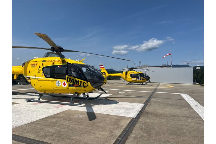 Zwei gelbe Notarzthubschrauber auf einem Dachlandeplatz