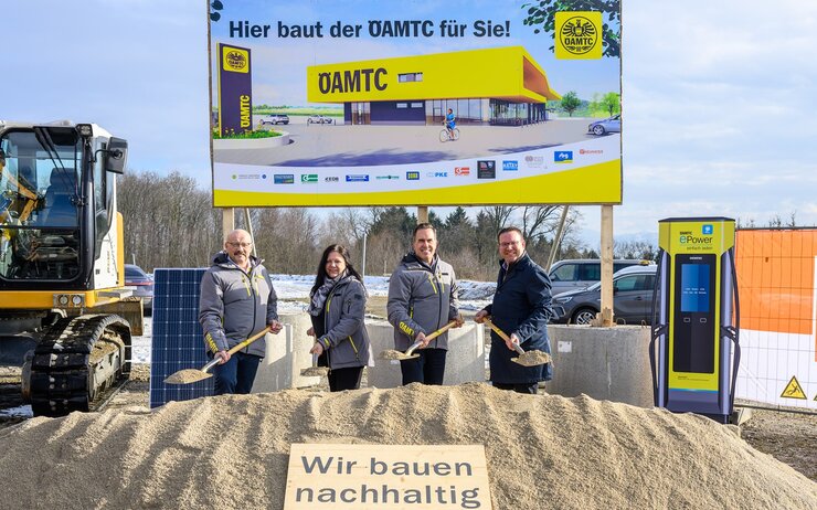 Gerhard Prantner, Alexandra Weidl, Oliver Krupitza und Christian Haberhauer beim Spatenstich für den neuen ÖAMTC Stützpunkt Amstetten auf der Baustelle mit einer Bautafel und Bagger als Hintergrundkulisse