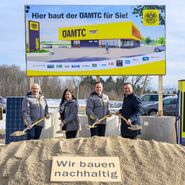 Gerhard Prantner, Alexandra Weidl, Oliver Krupitza und Christian Haberhauer beim Spatenstich für den neuen ÖAMTC Stützpunkt Amstetten auf der Baustelle mit einer Bautafel und Bagger als Hintergrundkulisse
